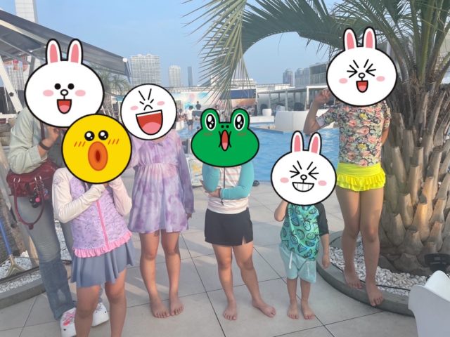 プールサイドで集合写真を撮る子ども