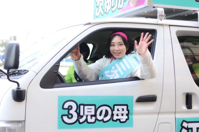 選挙カーから笑顔で手を振る三次ゆりか